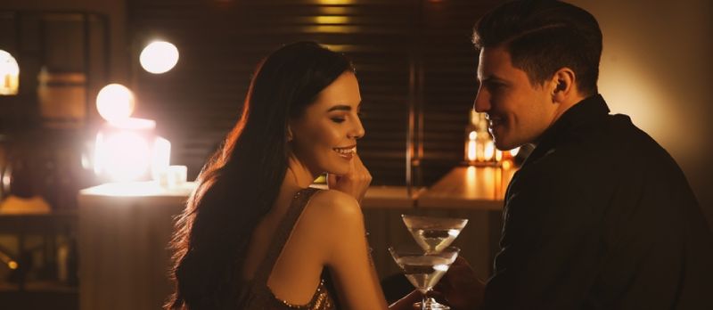 Homme et femme flirtant entre eux au bar