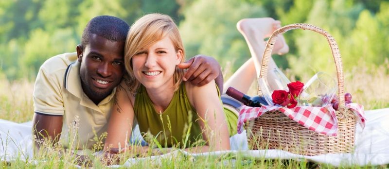 retrato, de, joven, pareja multiétnica, merienda campestre en el parque