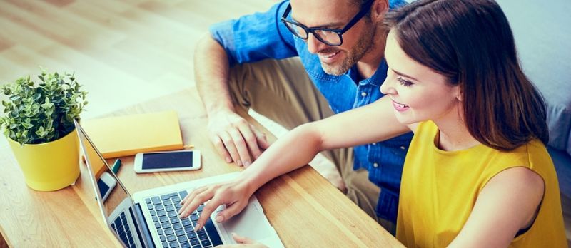 Coppia felice che fa shopping online insieme a casa