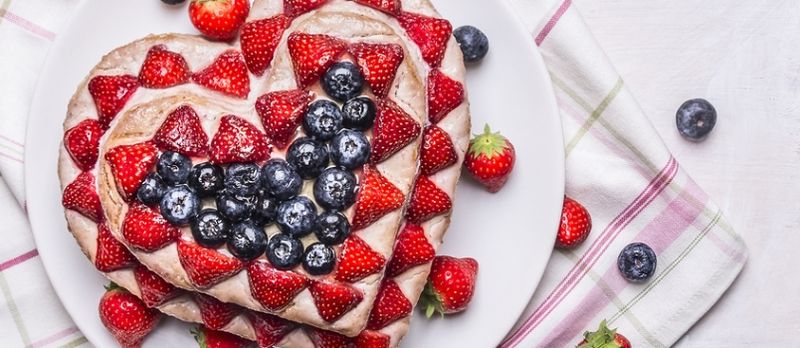 Délicieux gâteau maison frais avec des fraises et des myrtilles en forme de coeur