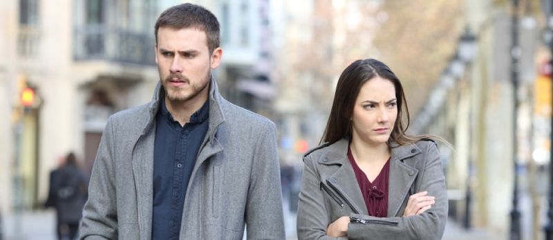 Retrato de vista frontal de una pareja enojada caminando en la calle después de un argumento