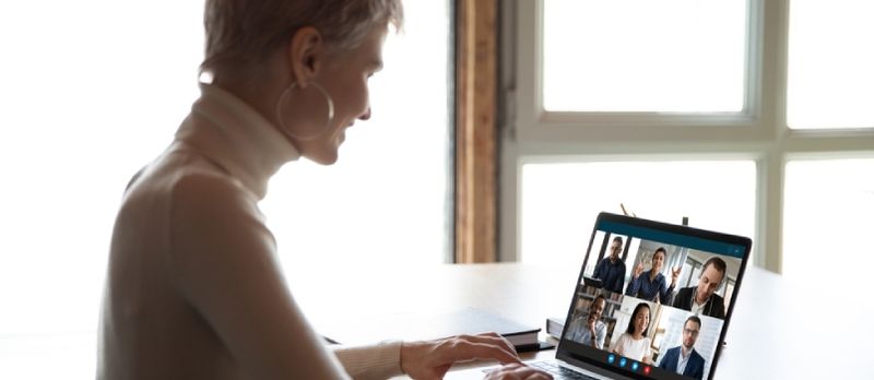 Smilende kvinne Sitt ved skrivebordet Ha webkamerakonferanse med forskjellige kolleger hjemme, forretningskvinne snakker Snakke på videosamtale med kollegaer på nettbasert briefing eller konsultasjon ved hjelp av webkamera på bærbar datamaskin