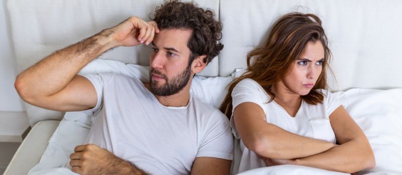 Vista Superior De La Joven Pareja Acostada En La Cama. Pareja Teniendo Una Pelea En La Cama. Concepto Sobre Relación Y Problemas Entre Parejas.