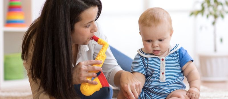 Femme et bébé jouant des jouets musicaux en pépinière