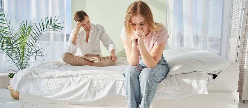 Pareja Joven Peleó Y Se Sentó Molesto En La Cama. El concepto de problemas de relación