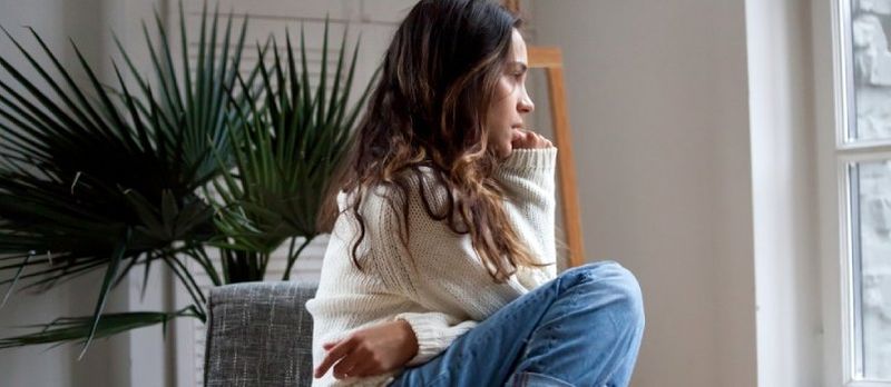 Trist omtenksom tenåringsjente sitter på stol og føler seg deprimert, fornærmet eller ensom