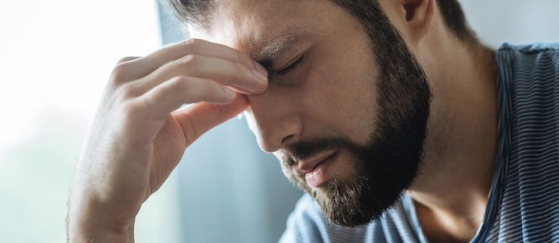 Burun körpüsünü tutan Moody Gənc Adam