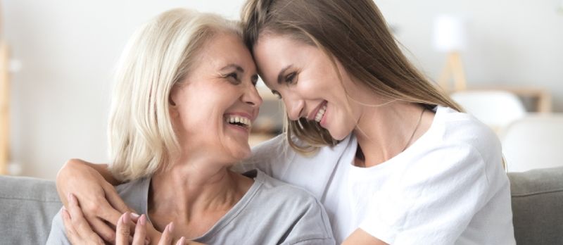 Heureuse mère mature aimante plus âgée et fille du millénaire cultivée riant embrassant, attentionnée souriante jeune femme