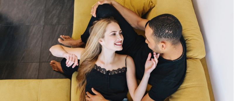 Senhora maravilhosa deitada na coxa do marido em casa e tocando seu rosto no amor