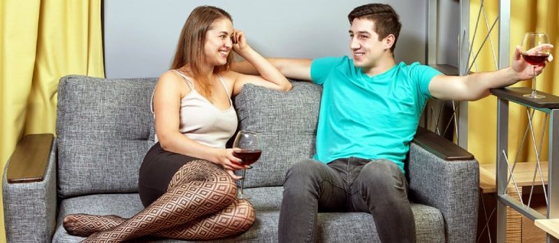 Jonk Passonate Koppel schwätzt Zesummen um Sofa An der Stuff