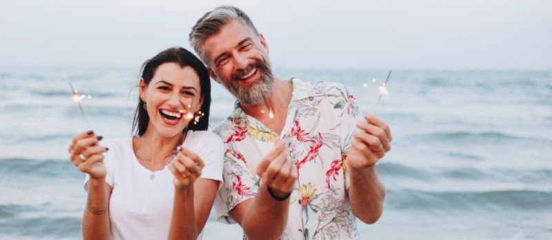 Casal comemorando com estrelinhas na praia