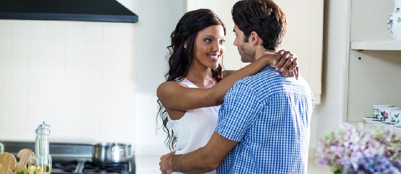מענטשן און פרויען אין אַ ראָמאַנטיש שטימונג אין קיך ענדזשויינג זיך