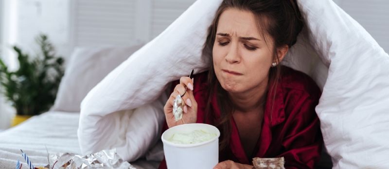 Knust kvinne som spiser mye desserter på grunn av depresjon og enormt stress på jobben