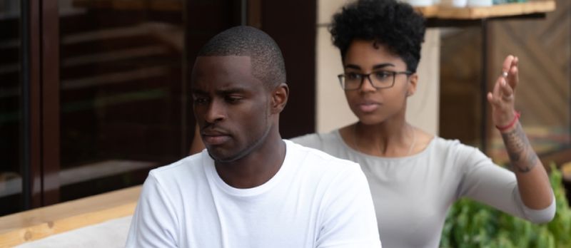 Afroamerikanesch jonk Koppel sëtzt dobausse mat Kampf oder Mëssverständnis Konflikt