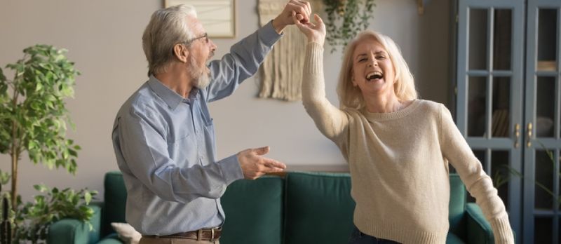 Couple de personnes âgées dansant ensemble à la maison