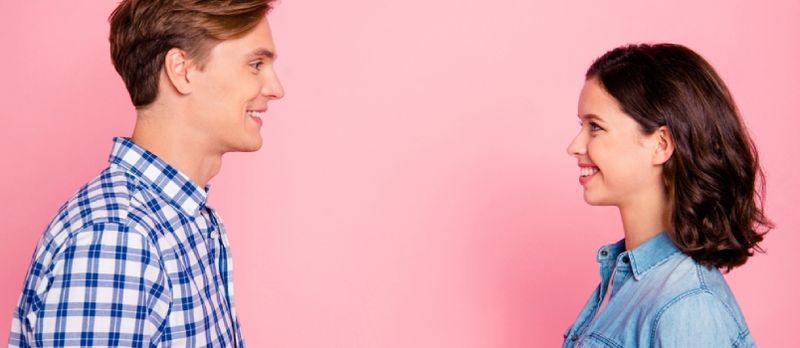 Profiel zijaanzicht portret van aardig mooi charmant aantrekkelijk vrolijk flirterig paar kijken naar elkaar praten gesprek verbinding Soulmate
