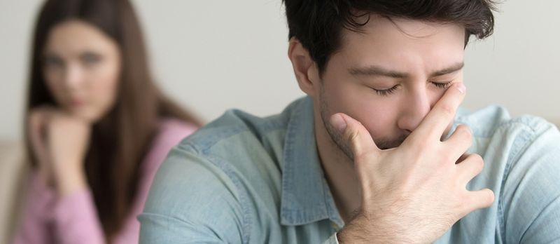 Gənc Oğlan Çox Kədərlidir və Ağlayır, Özünü Günahkar Hiss Edir, Ağrıda Depressiyada Adam, Arka Planda Oturan Qız Rəfiqəsi