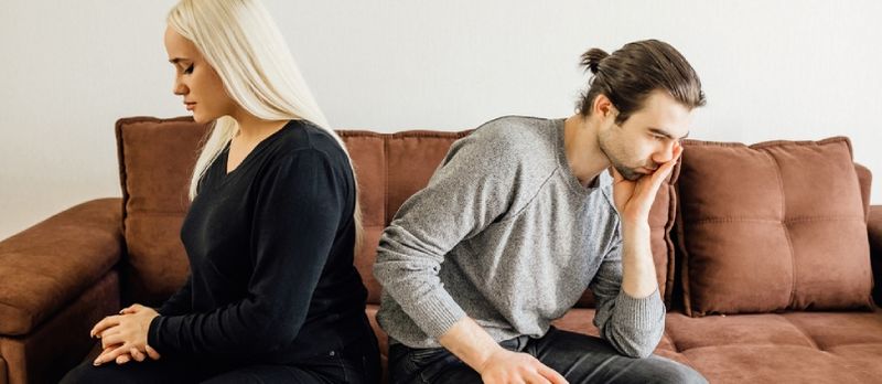 Os cónxuxes sentan separados no sofá da casa Ignóranse entre eles Evite falar despois de discutir