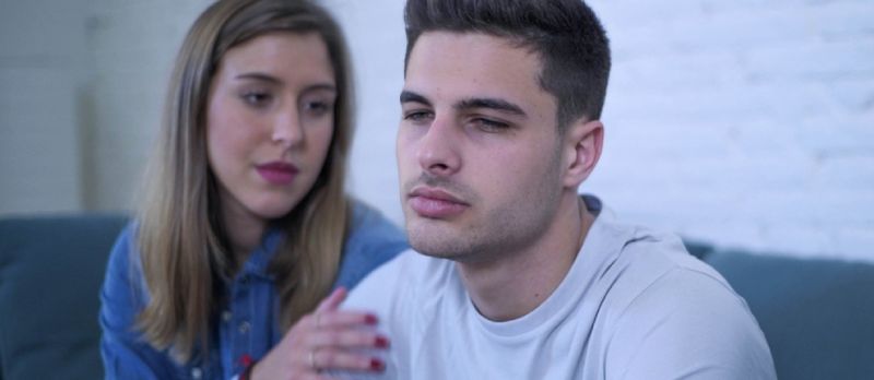 20 yaşlı gənc Cütlük Ev Divanında Oturmuş Kədərli və Depressiyada Ağrılı Adamla Ürəyi Qırmış Və Sevgilisinə Problemlərdə Kömək və Rahatlıq Verir və Həyat Tərzi Anlayışı