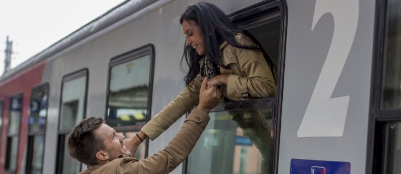 Man släpper kvinnor på tåget på järnvägsstationen Långdistansförhållande koncept