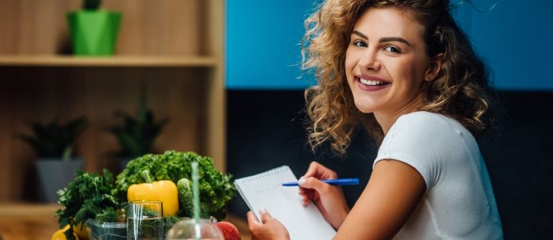 Nutrizzjonista Jaħdem Fl-Uffiċċju. Tabib Jikteb Pjan tad-Dieta Fuq Mejda U Juża Ħxejjex
