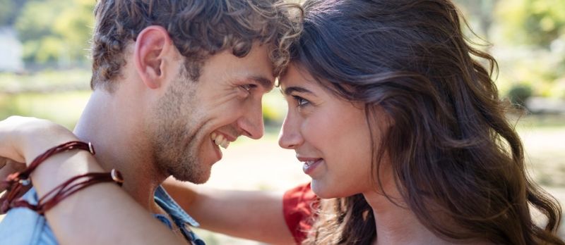 Couple romantique se regardant dans le parc par une journée ensoleillée