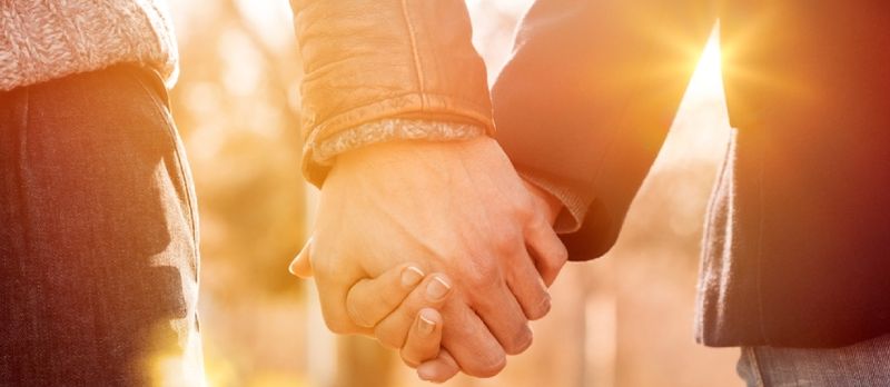 Staġun tax-Xitwa Bir-Raġġi tax-Xemx Koppja Żomm idejhom Flimkien Shot Closeup