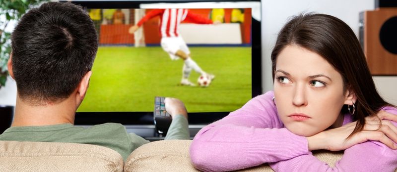 Obraz kobiety się nudzi, podczas gdy jej partner ogląda sport, jestem autorem obrazu na ekranie telewizora
