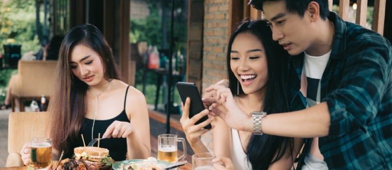 Azjatycka kobieta samotna zazdrosna o miłość para robi Take Selfie w restauracji.