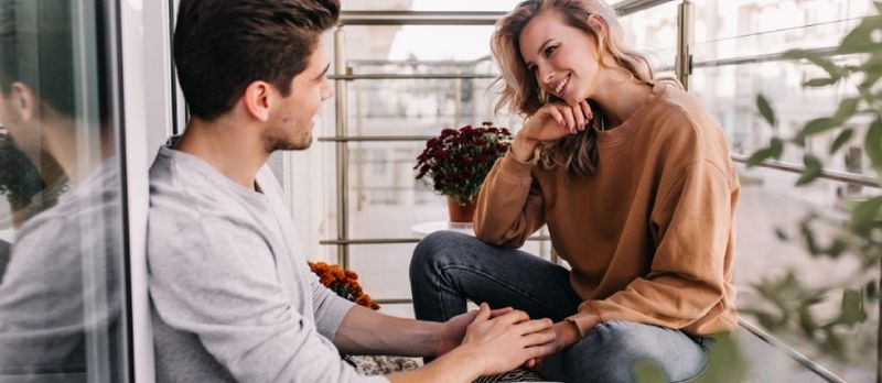 Sorrindo casal apaixonado na varanda, comunicando-se juntos