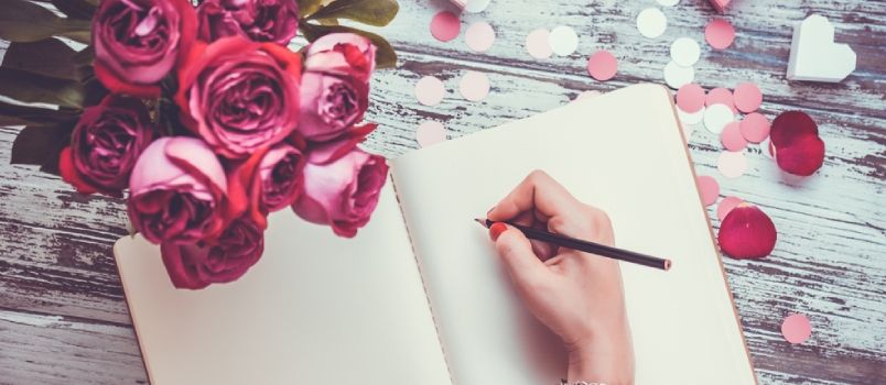 Köhnə Taxta Masa Üzərində Açıq Notebook Və Buket Gül Yazan Əllər. Üst Görünüş
