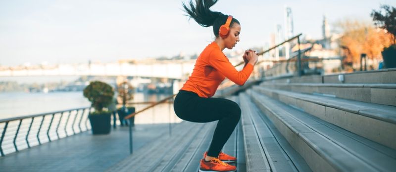 Fitnessinaine hüppab linnakeskkonnas õues